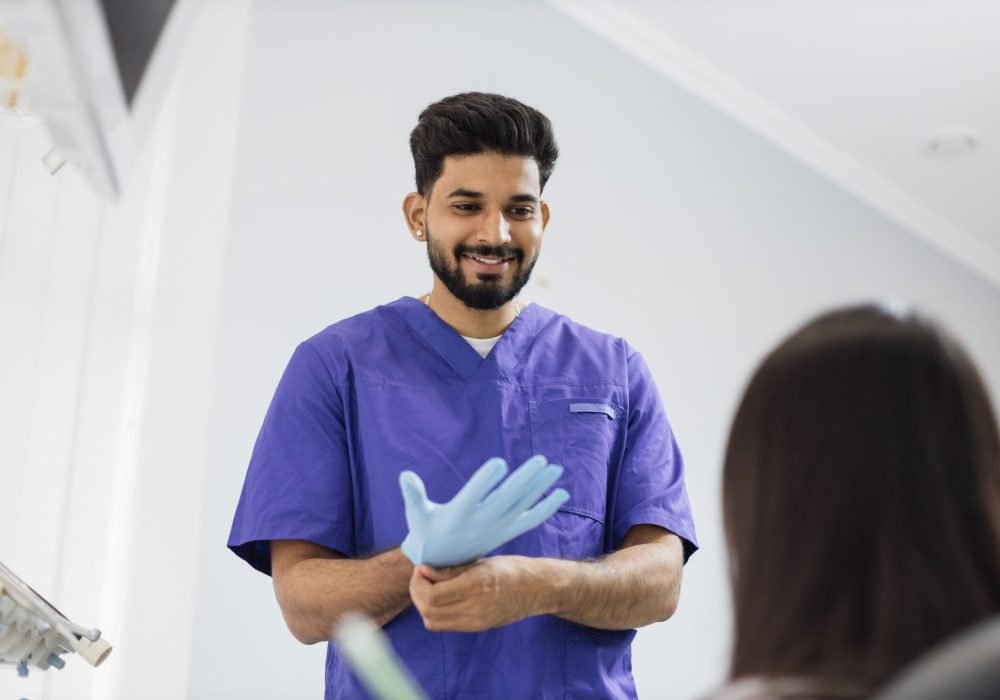 confident-bearded-male-dentist-puts-on-blue-rubber-2022-12-13-21-42-08-utc